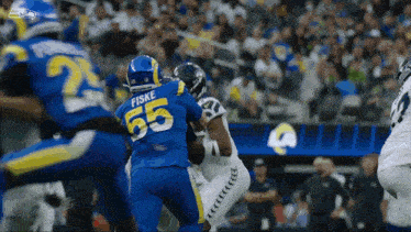 a football player with the number 55 on his jersey is being tackled by another player