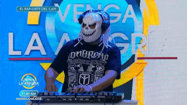 a man wearing a skull mask is playing music on a mixer