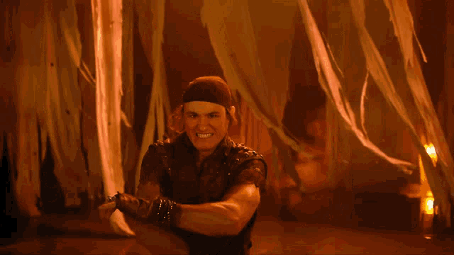 a man wearing a headband and gloves is holding a sword