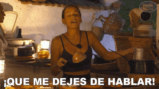 a woman is standing in front of a table with the words que me dejes de hablar below her