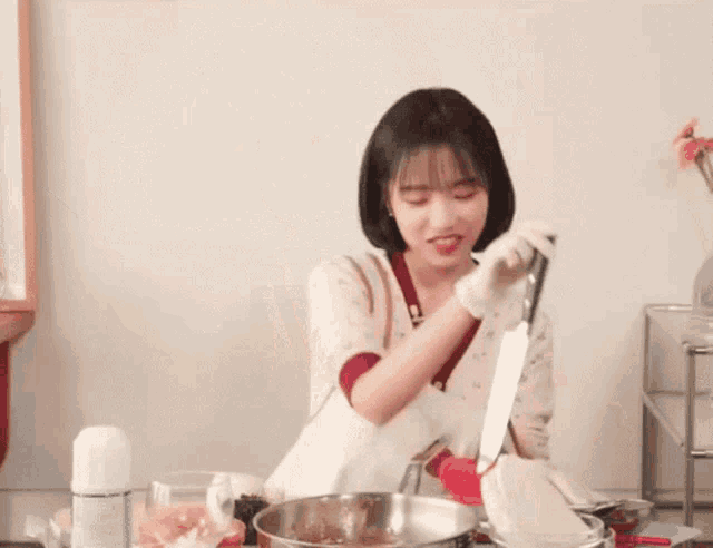 a woman in a white apron is holding a large knife