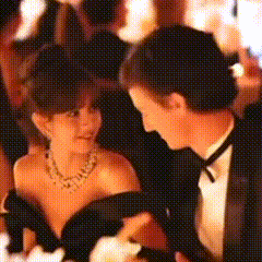 a man in a tuxedo holds a woman in a black dress