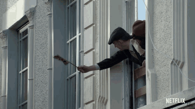 a netflix ad shows a man holding a piece of paper in a window