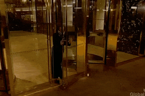 a woman stands in front of a glass door that says global on the bottom