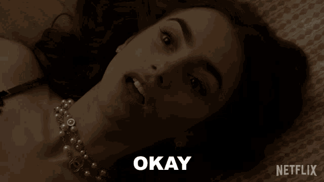 a woman laying on a bed with okay written on the bottom