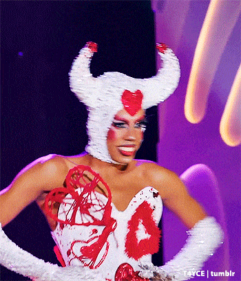 a woman is wearing a white and red costume with horns and a heart on it
