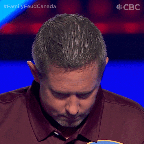 a man in a maroon shirt is playing a game on a tv show called family feud canada
