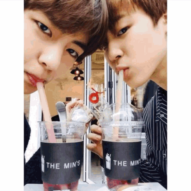 two young men drinking from cups that say the min 's on them