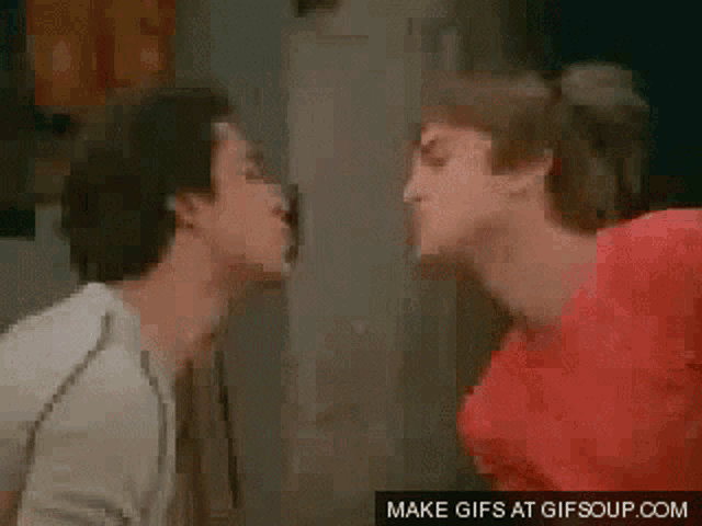 two men are kissing in front of a mirror and the words make gifs at gifsoup.com are on the bottom