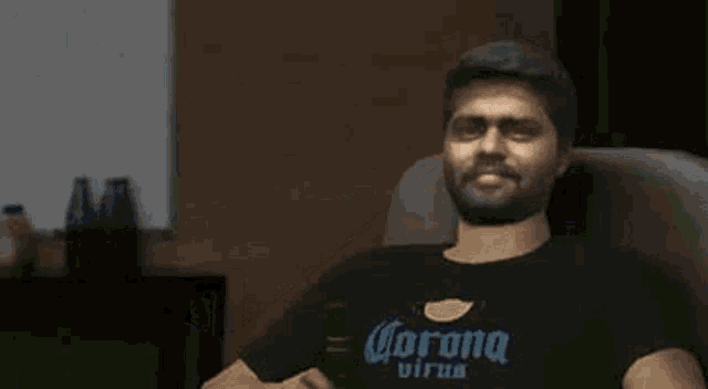 a man is sitting in a chair drinking a bottle of beer .