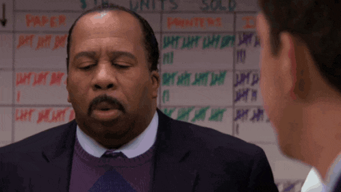 two men are standing in front of a white board that says units sold