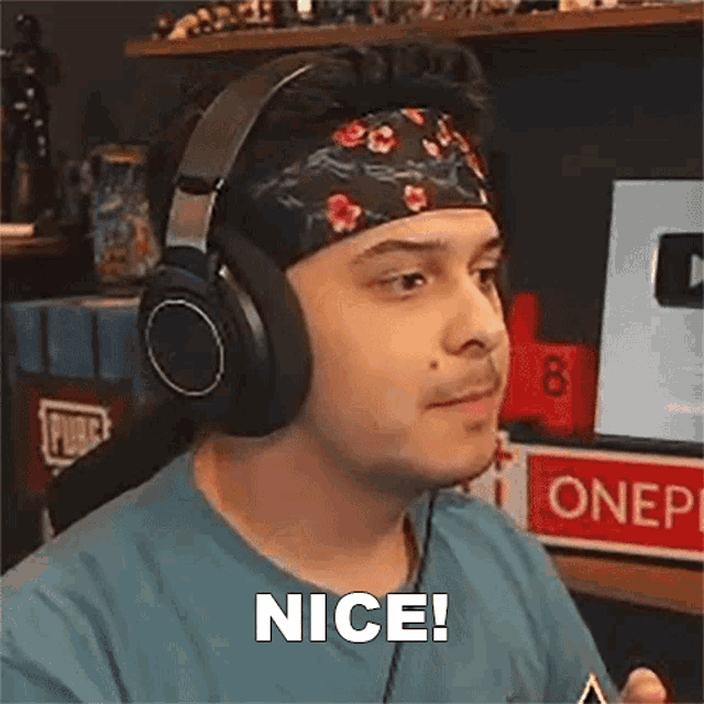 a man wearing headphones and a headband is making a face and saying nice .