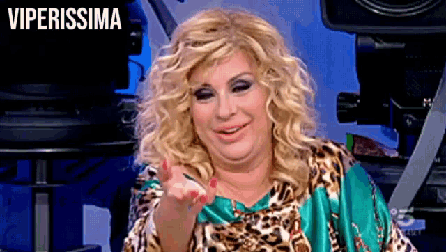 a woman in a leopard print shirt is pointing at the camera with the word viperissima above her