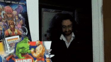 a man is standing in front of a marvel poster