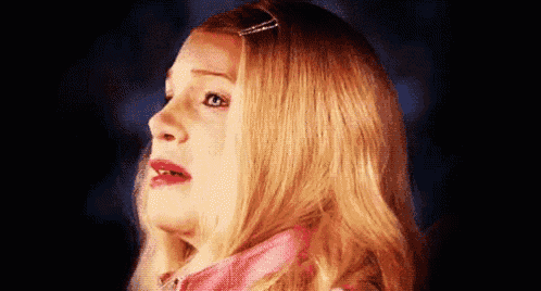 a close up of a blonde woman 's face with a surprised look on her face
