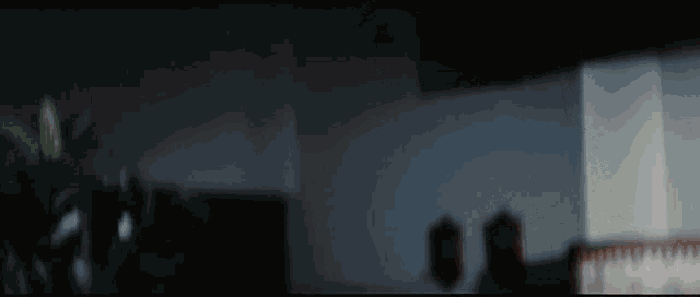a blurred image of a room with a plant in the foreground