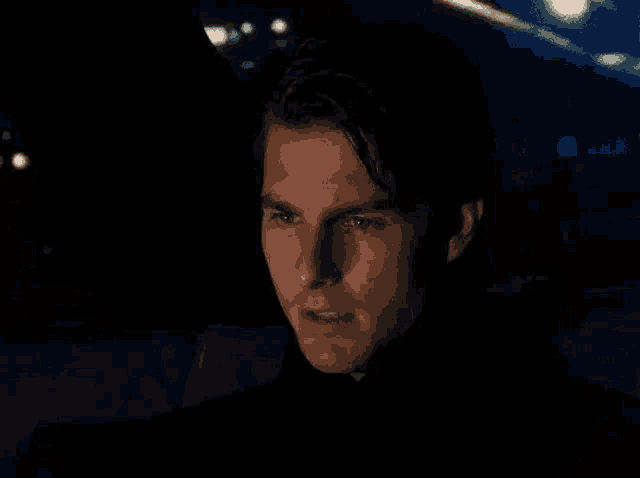 a close up of a man 's face with his eyes closed in a dark room .
