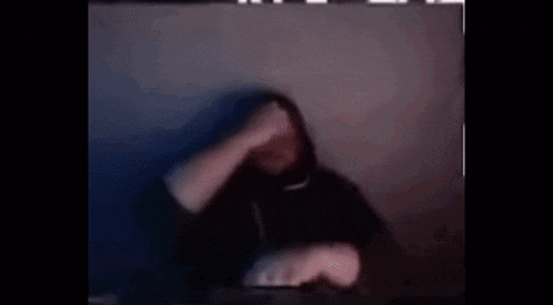a blurry picture of a person in a hoodie covering their face .