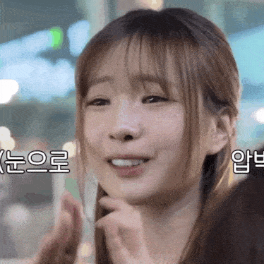 a close up of a woman 's face with korean writing on the bottom right