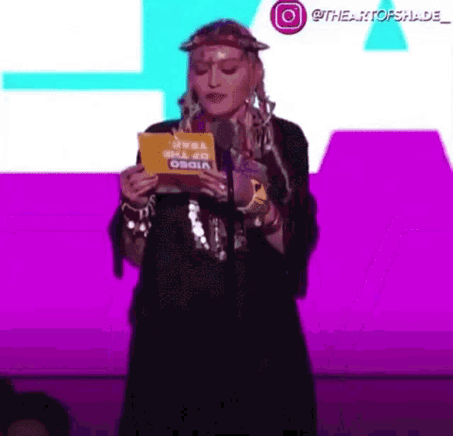 a woman is holding a card that says video of the year on it