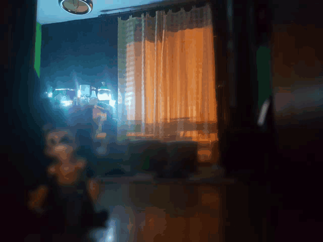 a dark room with a clock on the ceiling and a window