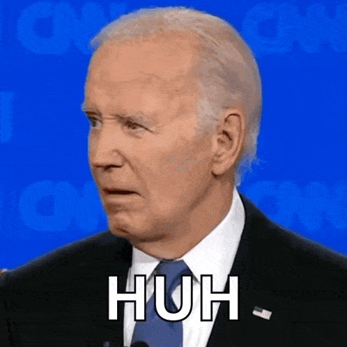 a close up of a man in a suit and tie making a funny face and saying huh .