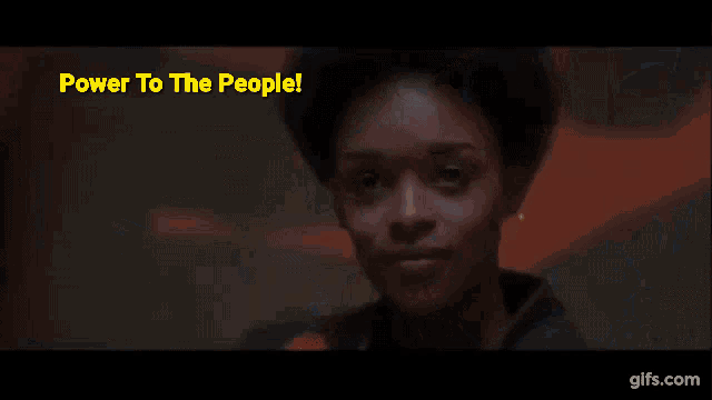 a man and a woman are sitting in a crowd with the words power to the people below them