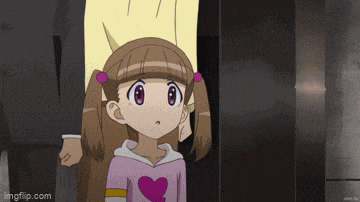 a little girl with pigtails and a heart on her shirt is standing next to a man .