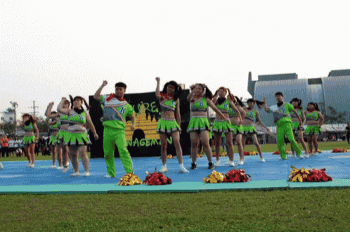 a group of cheerleaders perform in front of a sign that says nagem