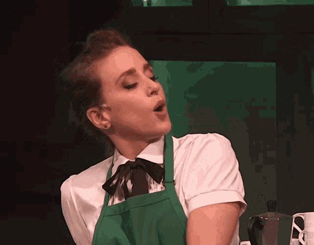 a woman wearing a green apron and a bow tie