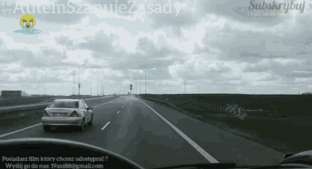 a car is driving down a highway with a watermark that says subskrypuj