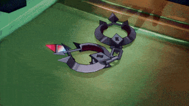 a pair of earrings laying on a green surface with a red stone in the middle