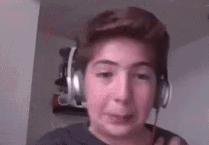a young boy wearing headphones is crying while making a funny face .