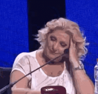 a woman is sitting at a table with a microphone .