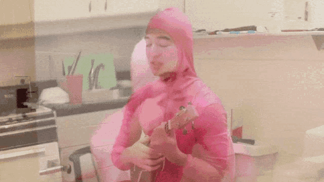 a man in a pink bodysuit is playing a guitar