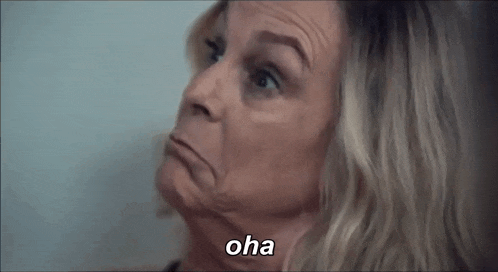 a close up of a woman making a funny face with the word oha written on the bottom .
