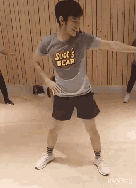 a man wearing a shirt that says succ 's bear is dancing