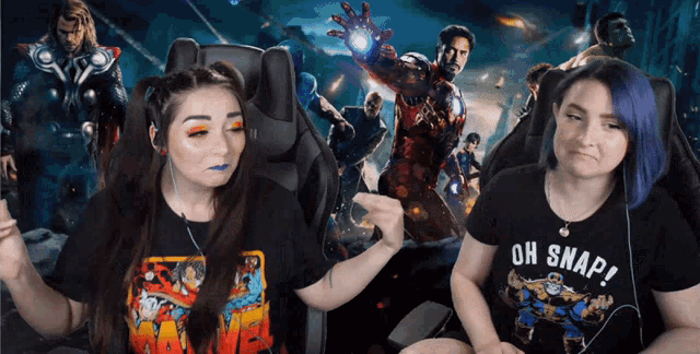 two women are sitting in front of a movie poster and one has an oh snap shirt on