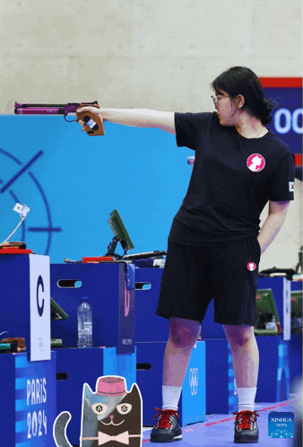 a woman is holding a gun in front of a paris sign
