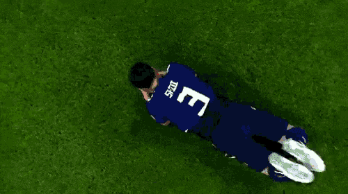 a soccer player with the number 3 on his back is laying on the grass
