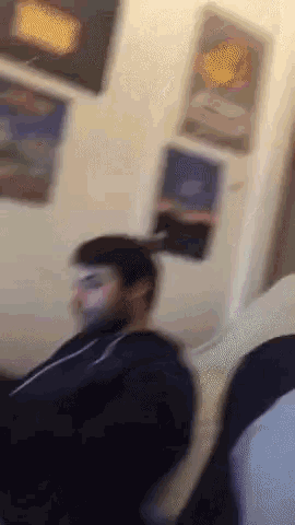 a blurry picture of a man sitting on a couch in a living room