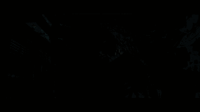 a man with long hair and a tattoo on his back stands in front of a wall with the letters eee written on it