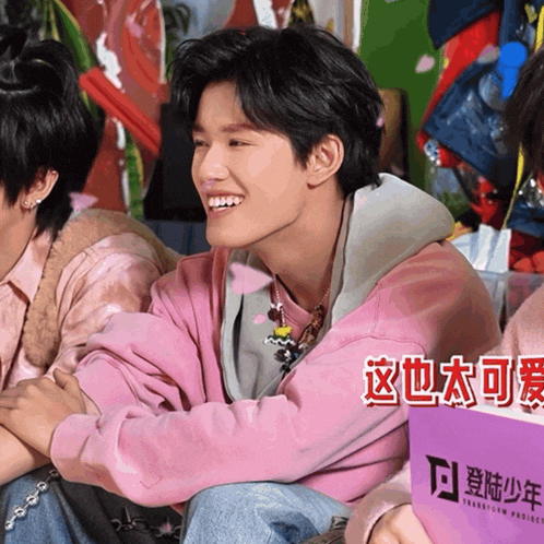 a man in a pink sweatshirt is smiling and holding a sign that says transition project