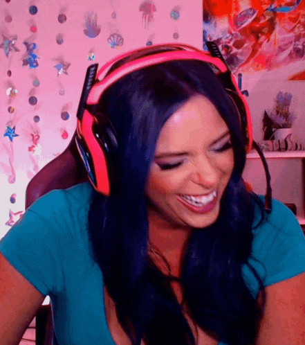 a woman with blue hair wearing a pair of pink headphones