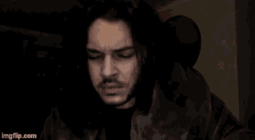 a man with long hair and a beard looks at the camera with imgflip.com in the lower right corner