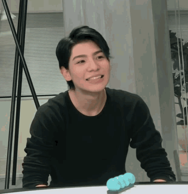 a man wearing a black shirt is smiling and looking at something