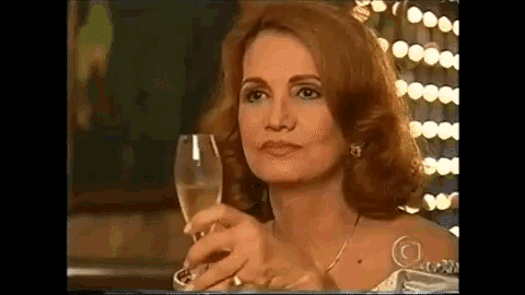 a woman in a white dress is holding a glass of champagne in her hand .