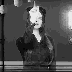 a black and white photo of a woman making a funny face .