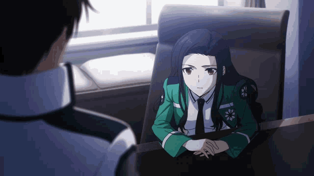 a girl in a green uniform sits at a table with a man