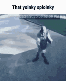 a man in a hoodie is standing on a sidewalk with the words `` that yoinky sploinky '' on the bottom .